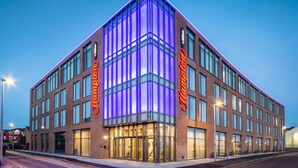 A modern hotel with a prominent 'Holiday Inn' sign, large windows, and a corner entrance. - Hampton by Hilton Blackpool (Blackpool)