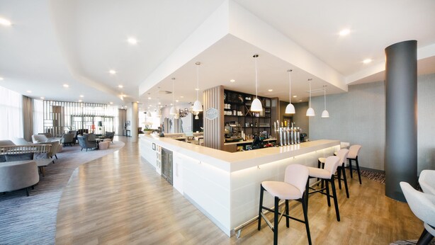 A spacious, modern kitchen with a central island, bar seating, and pendant lighting. - Hampton by Hilton Blackpool (Blackpool)