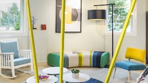 A modern living room with a sofa, chairs, a coffee table, and a lamp.