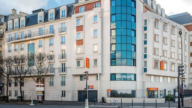 A multi-story hotel with a curved facade, large windows, and balconies.