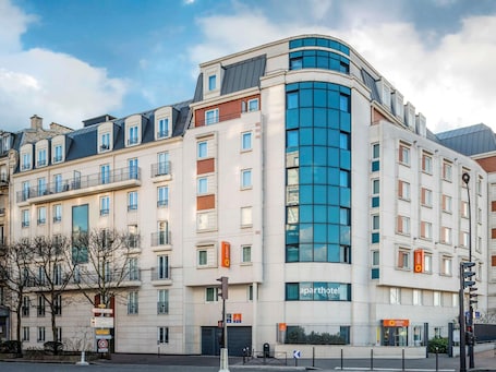 A multi-story hotel with a curved facade, large windows, and balconies.. Aparthotel Adagio Access Paris Porte de Charenton
