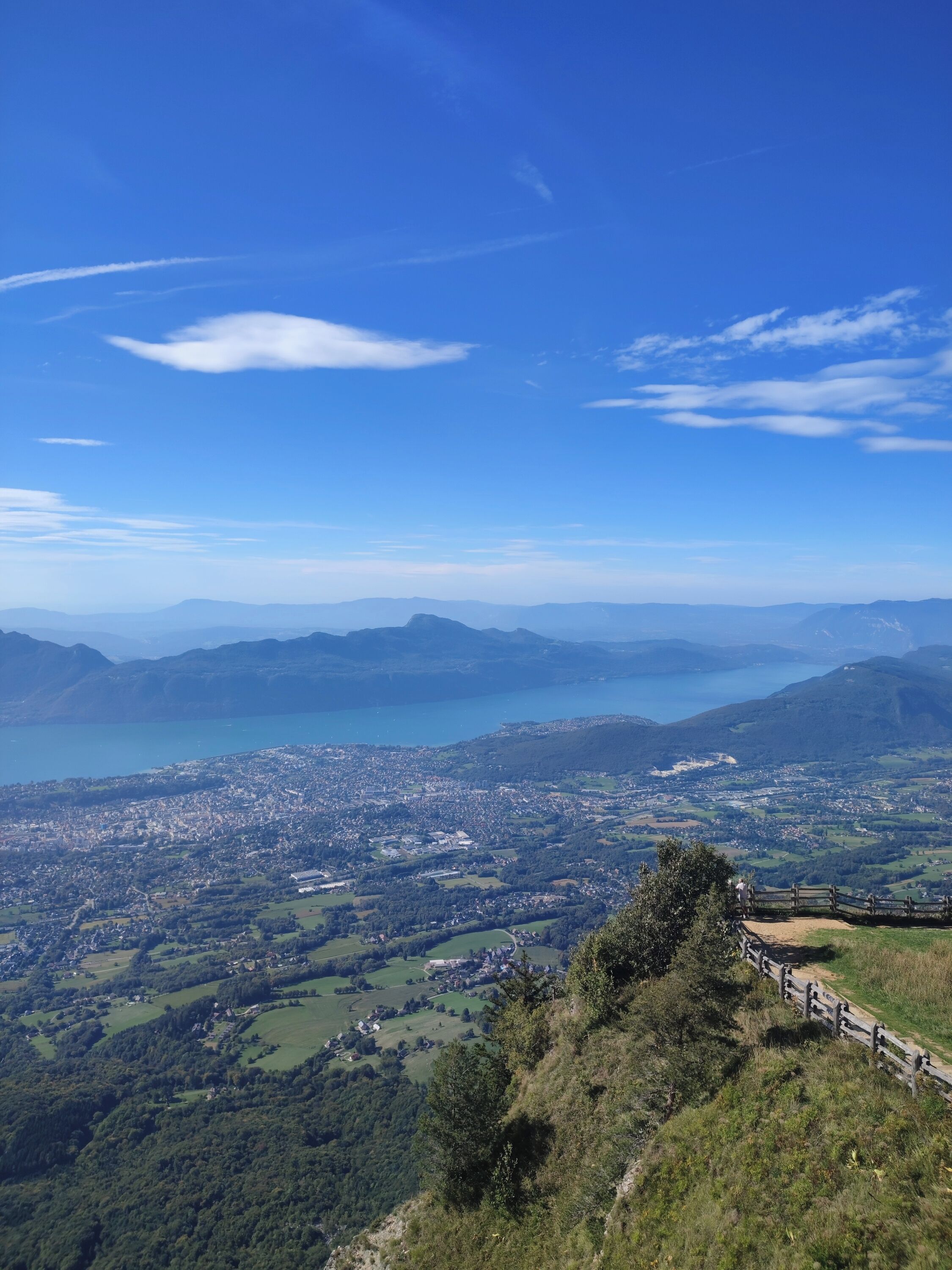 Vista panorámica de un paisaje montañoso con un lago y un pueblo abajo.