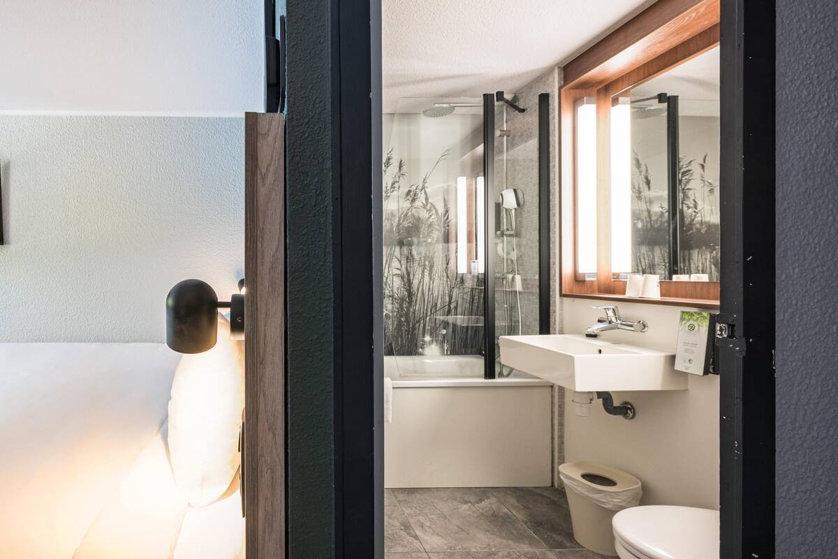 Ein modernes Badezimmer mit Badewanne, Toilette und Waschbecken.
