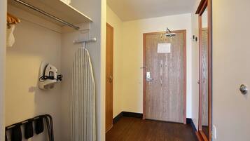 Un pasillo con una puerta de madera, un perchero para toallas y un perchero para abrigos.