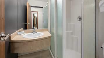 Ein modernes Badezimmer mit Waschbecken, Spiegel und Dusche.