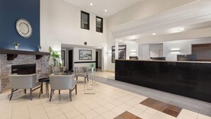 A modern lobby with a fireplace, seating area, and a reception desk.