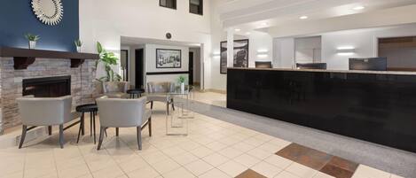 Eine moderne Lobby mit Kamin, Sitzecke und Rezeption.
