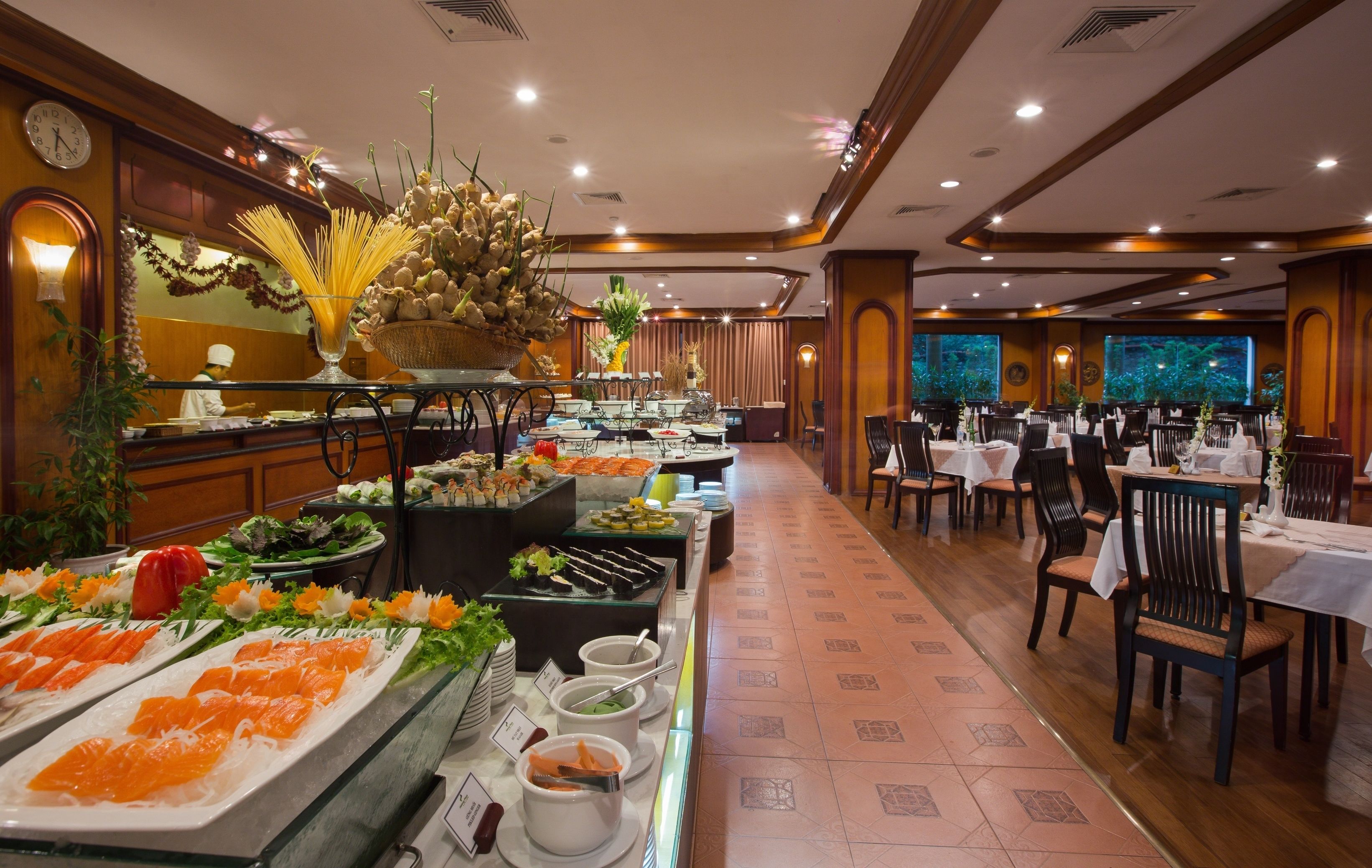 A buffet area with various food options and a dining area with tables and chairs.