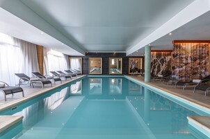 Una piscina techada, sillones reclinables de piscina