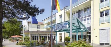 A hotel with a glass facade, a visible entrance, and a sign indicating it is a hotel.