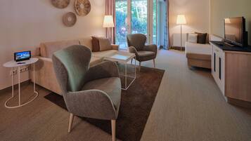 Una sala de estar moderna con un sofá, un sillón y un televisor sobre un mueble.