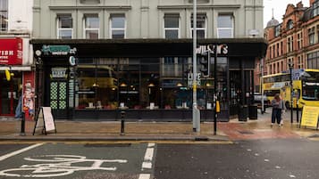 A street view with a comedy club, a fish center, and a bus stop.