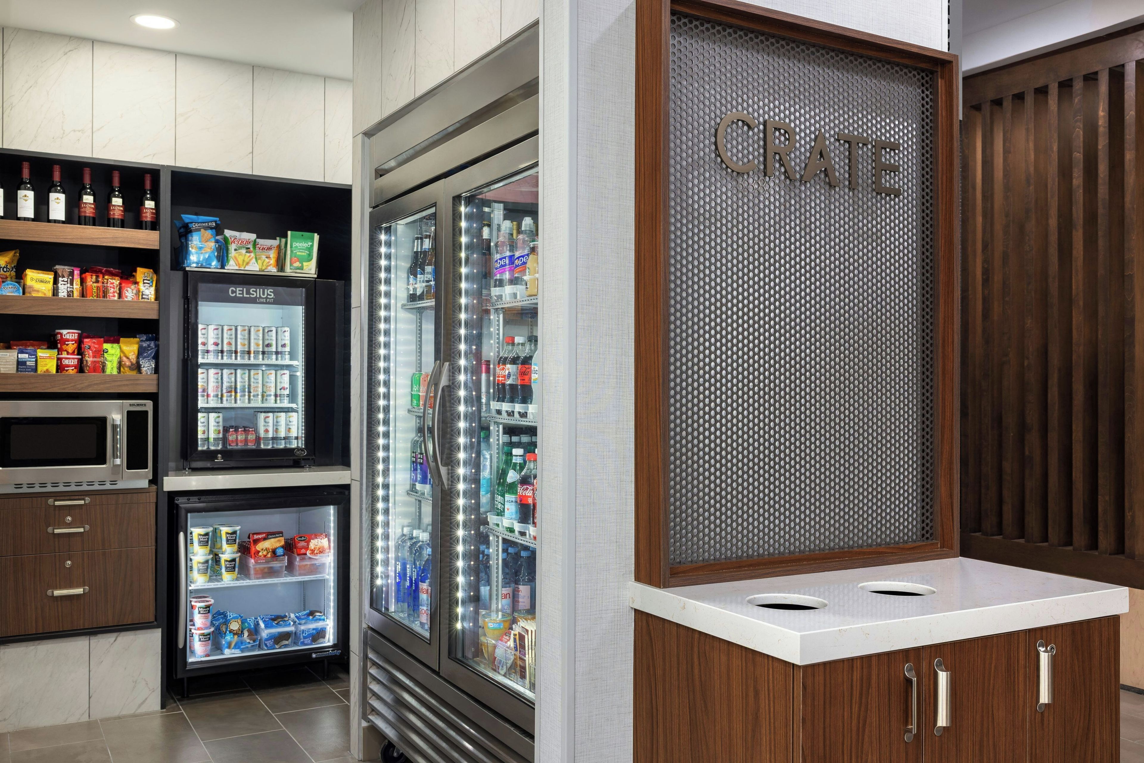 A kitchenette with a microwave, refrigerator, and a 'CRATE' sign.