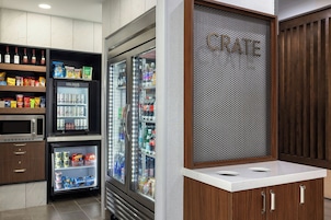 Una kitchenette con microondas, refrigerador y un letrero que dice 'CRATE'.