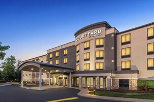 A Courtyard by Marriott hotel with a covered entrance, multiple floors, and a stone facade.