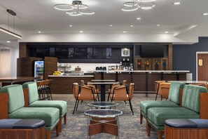 A modern hotel lobby with a bar area, seating, and a menu board. - Courtyard by Marriott Pittsburgh Monroeville (Monroeville)