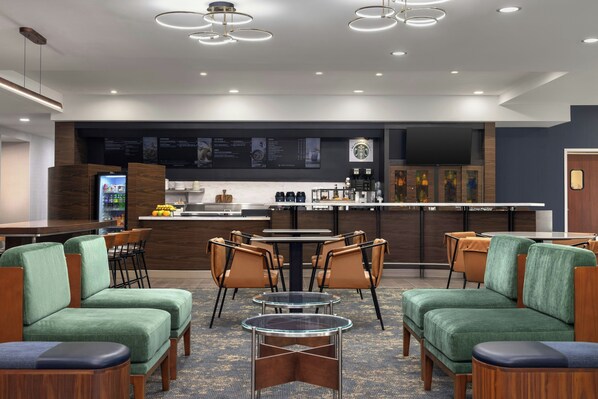 A modern hotel lobby with a bar area, seating, and a menu board. - Courtyard by Marriott Pittsburgh Monroeville (Monroeville)