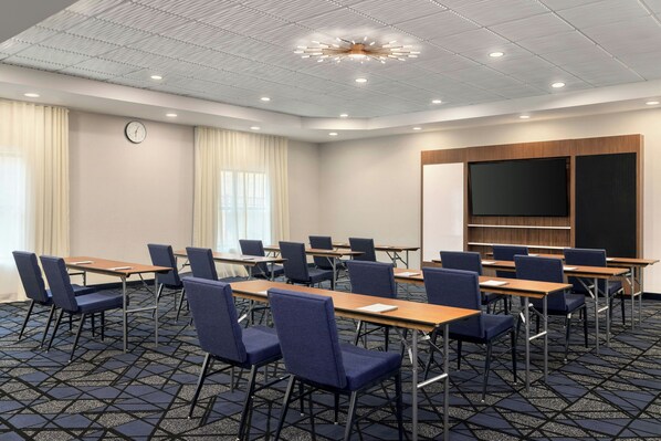A conference room with tables and chairs, a clock, and a large screen. - Courtyard by Marriott Pittsburgh Monroeville (Monroeville)