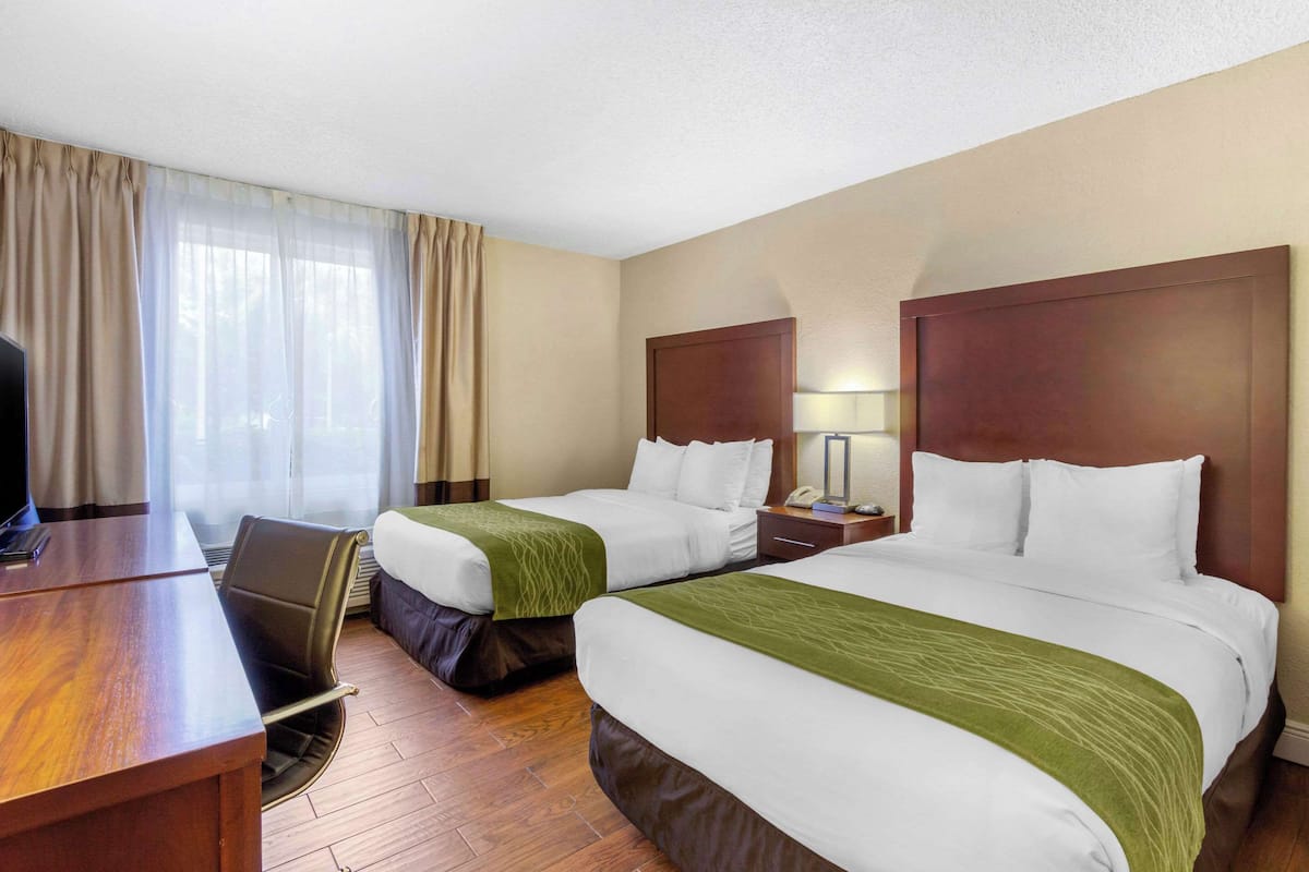 Una habitación de hotel con dos camas, un escritorio y una silla.