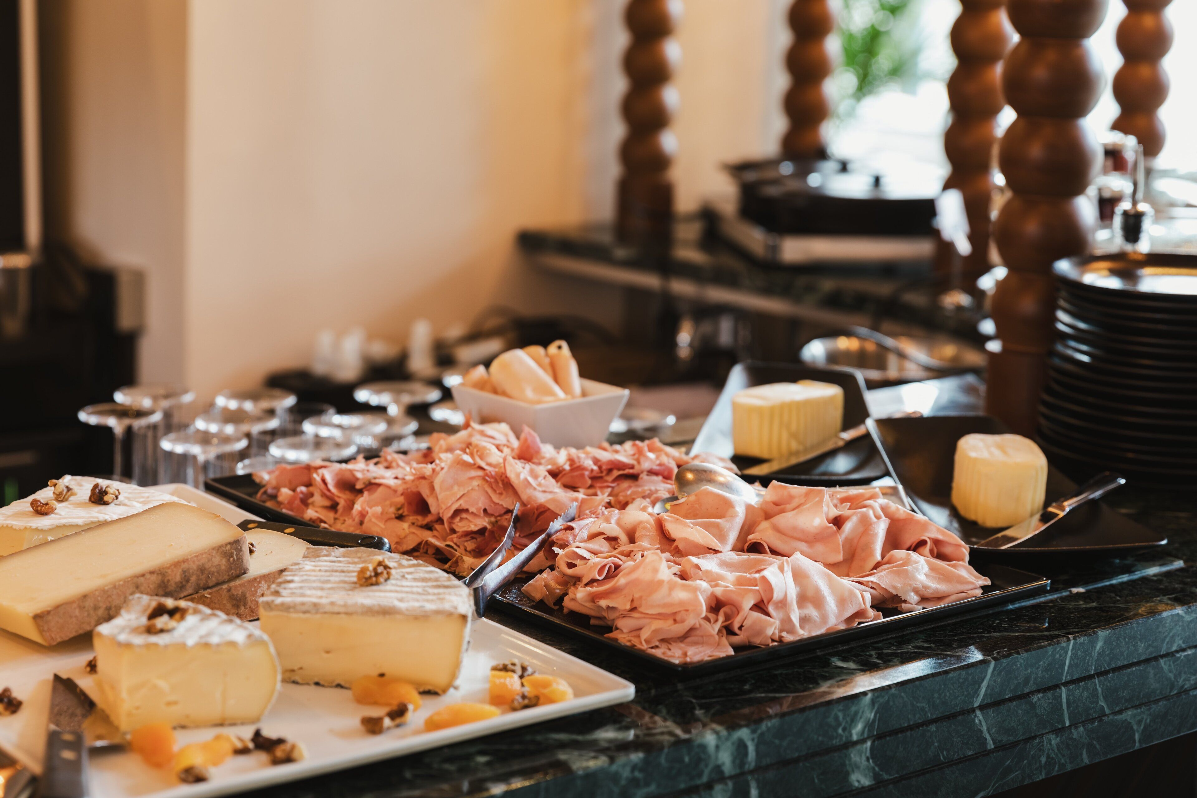 Ein Buffet mit verschiedenen Käsesorten, Fleisch und Obst.