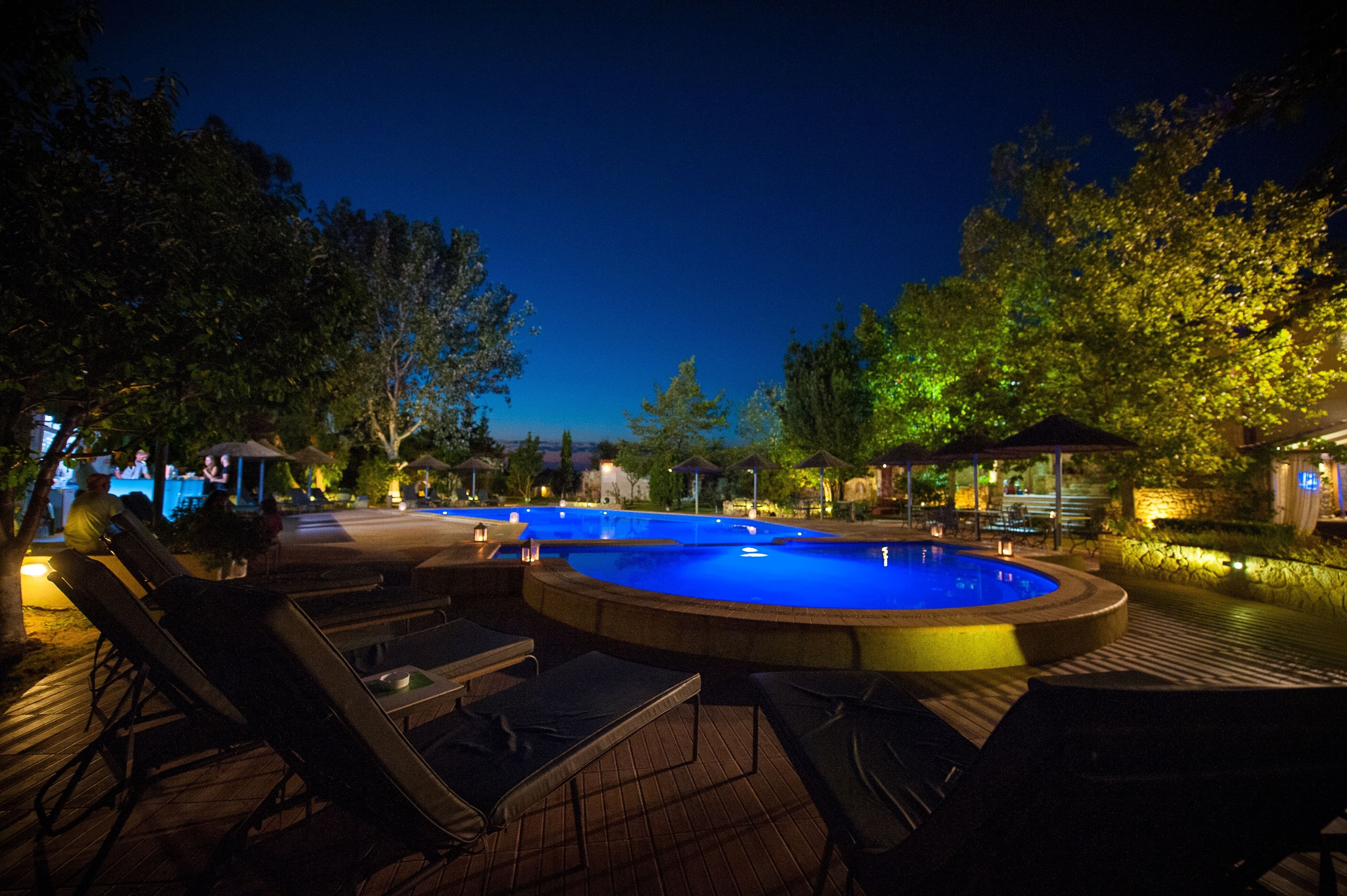 Una piscina al aire libre, sombrillas, tumbonas