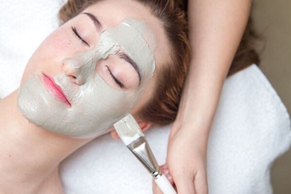 Una persona acostada mientras le ponen una máscara facial.