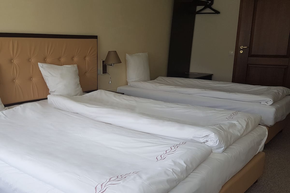 Economy Triple Room | Minibar, in-room safe, desk, blackout drapes