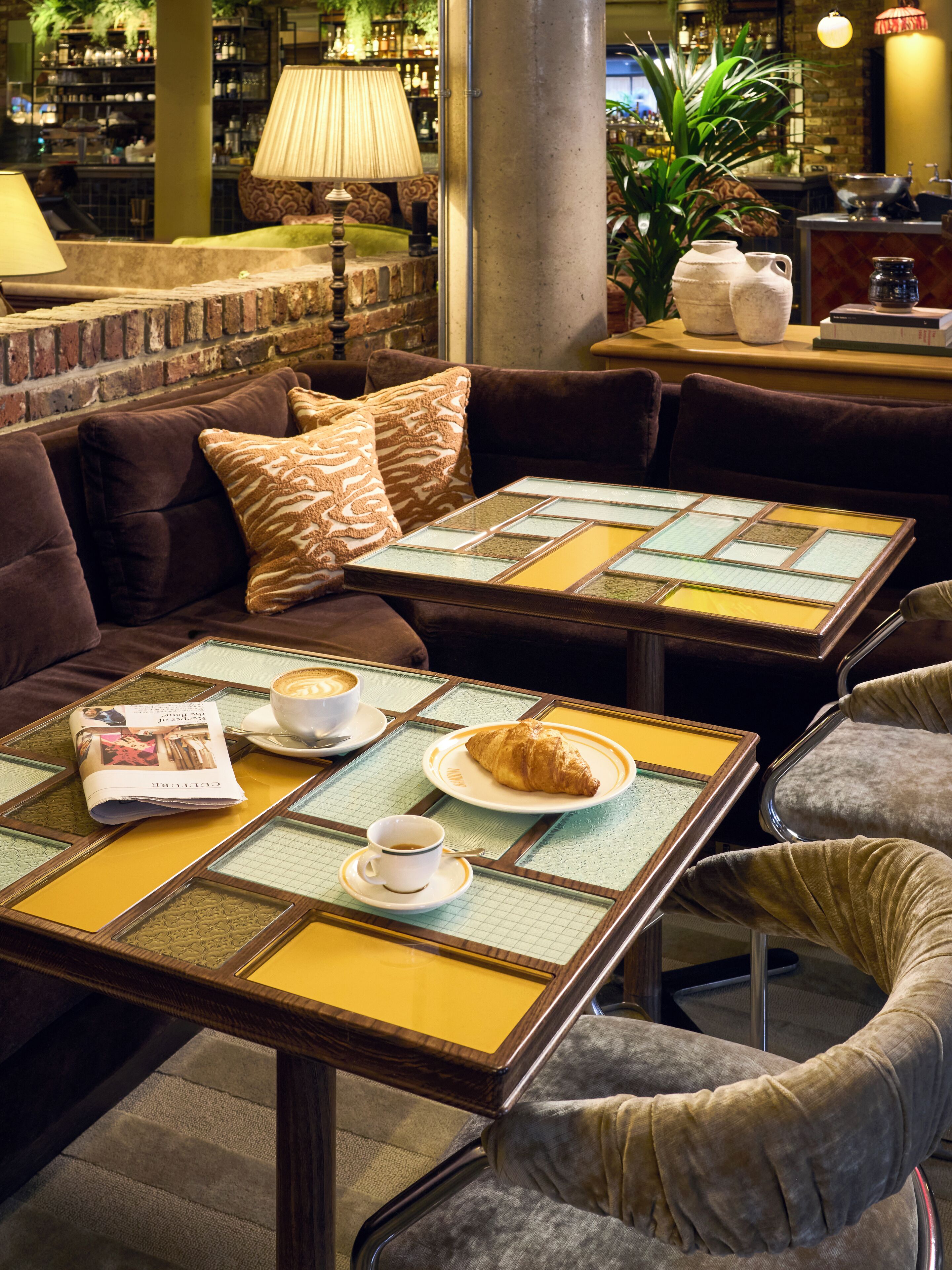 A cozy cafe with a sofa, tables, and chairs.