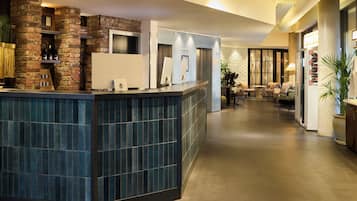 A reception area with a brick wall, a reception desk, and a seating area with sofas and a coffee table.