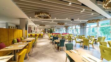 Un restaurante moderno con diversas opciones de asientos, incluyendo cabinas y mesas, y una barra central.