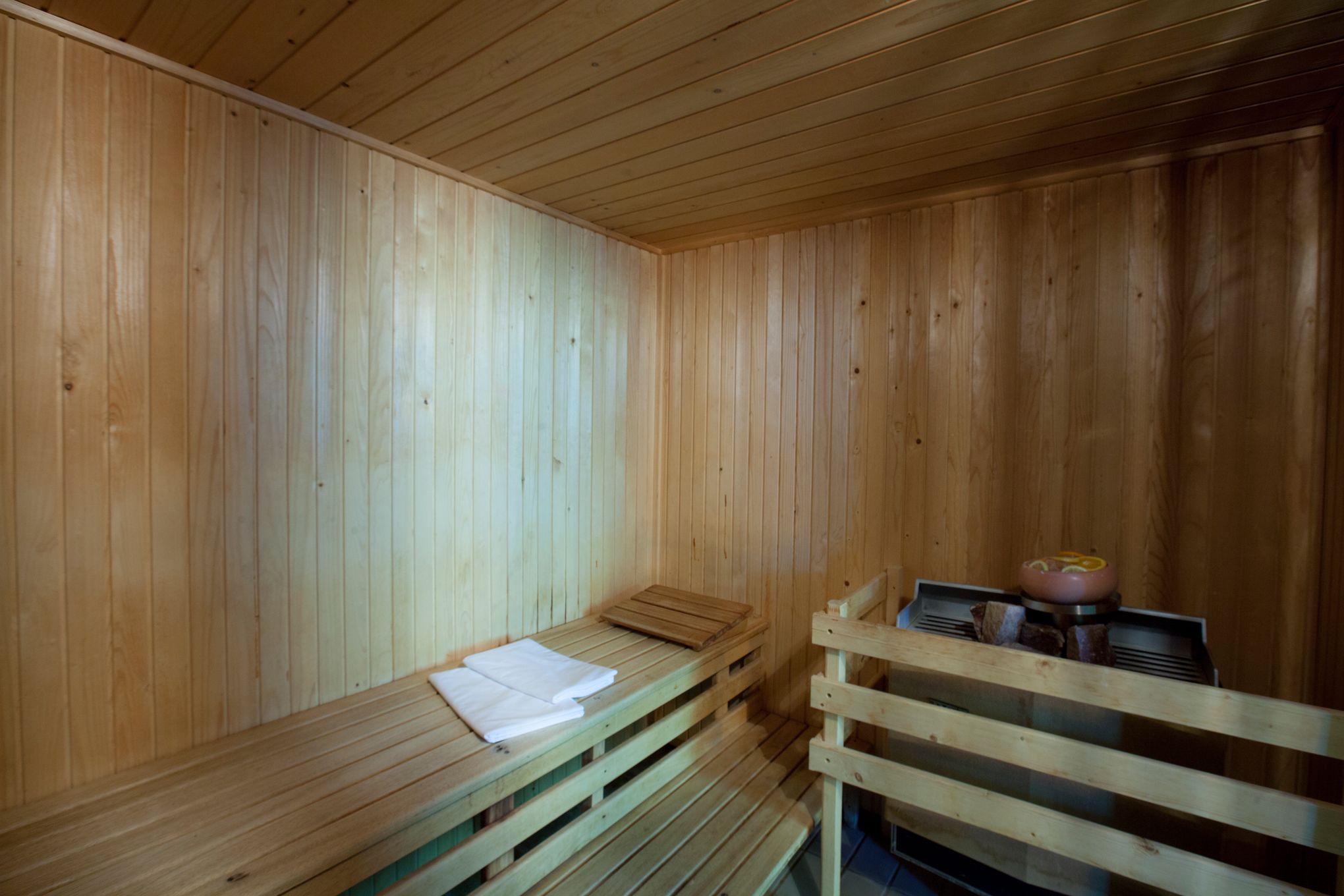 Una sauna de madera con bancos y un banco con toallas.