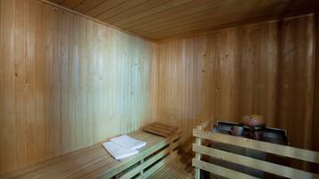 Una sauna de madera con bancos y un banco con toallas.