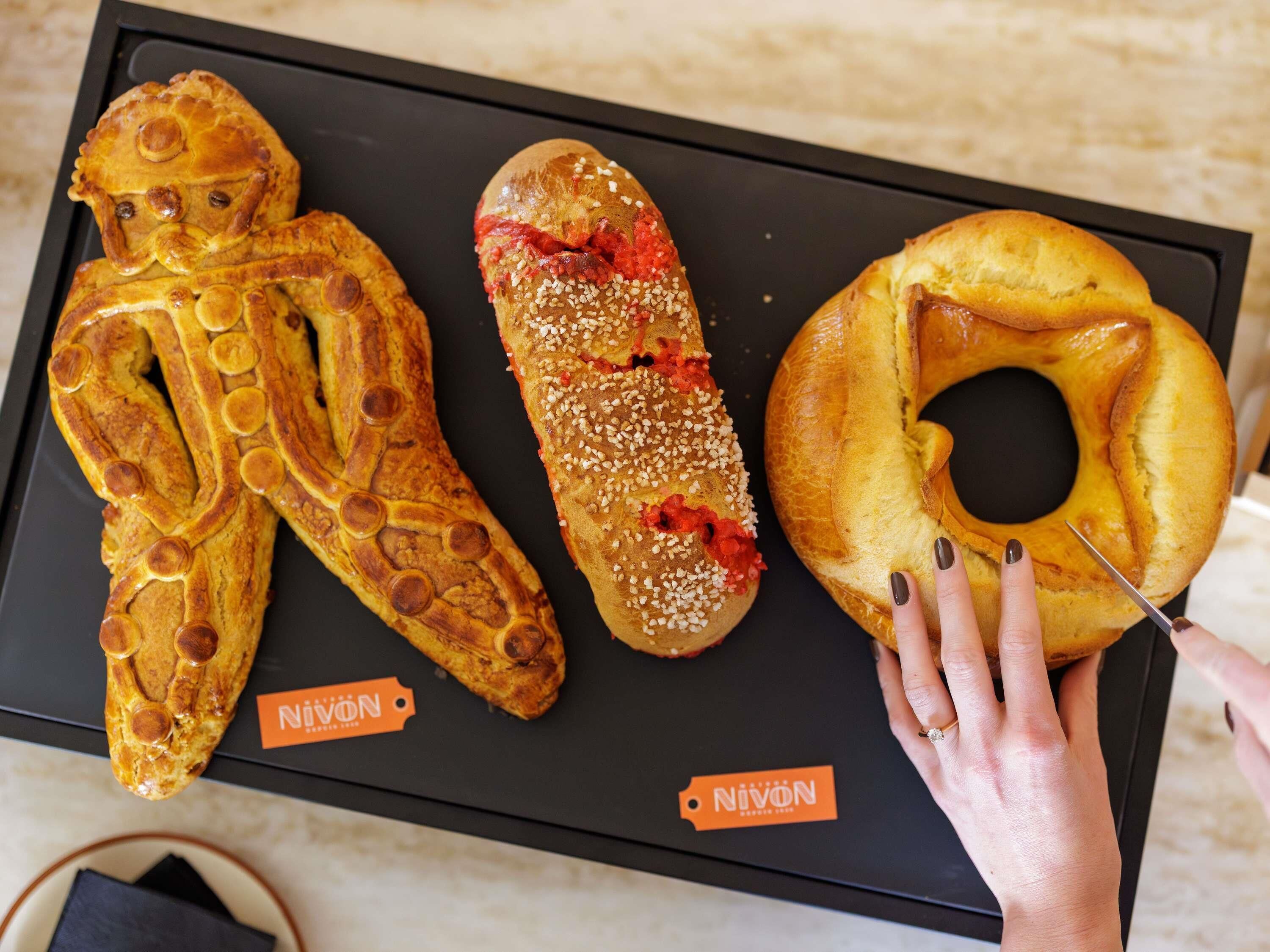 A tray with three pastries labeled 'NiVon' on a black surface.