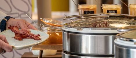 A buffet setup with various food items and utensils.