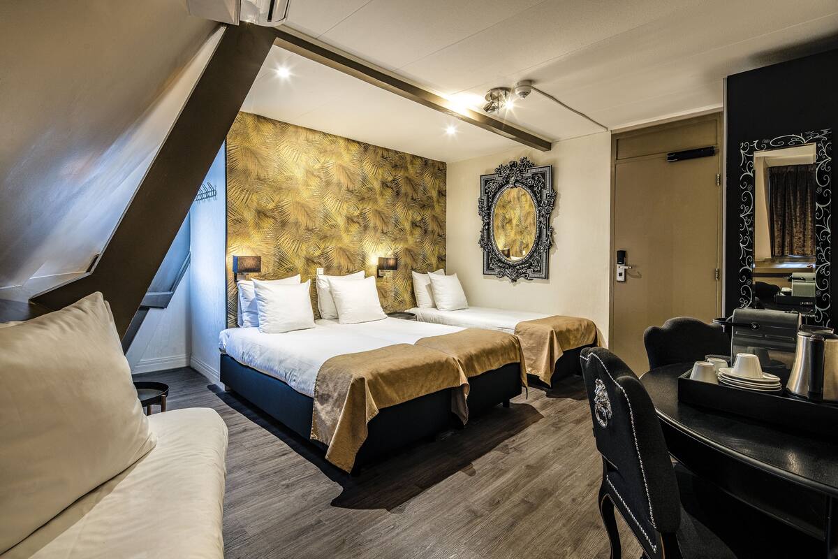 A hotel room with a large bed, a desk with a mirror, and a decorative wall panel.