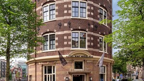 A multi-story hotel with a curved facade, large windows, and a prominent entrance.