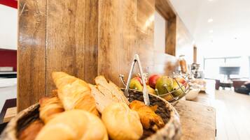 Une table en bois avec un panier de pain et des pommes.