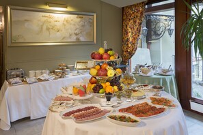 Une table de buffet garnie de divers plats et un grand tableau accroché au mur.
