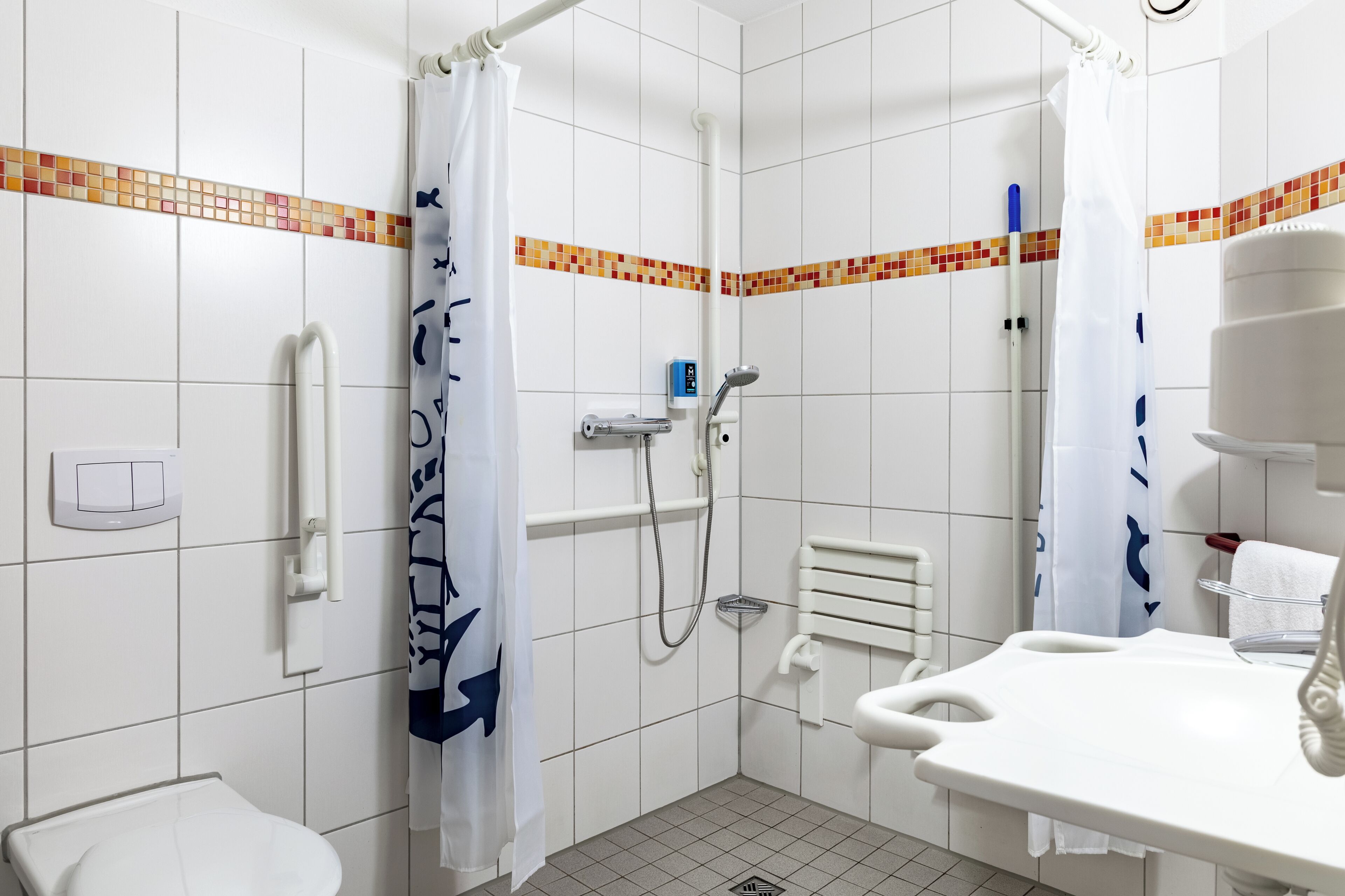 Ein kleines Badezimmer mit Fliesen, einer Dusche, einer Toilette und einem Waschbecken.