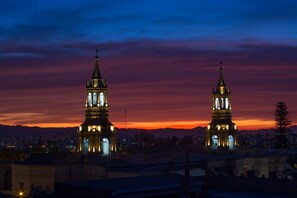 Dos torres de iglesia iluminadas contra un cielo al atardecer.