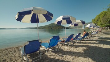 En la playa, sillas reclinables de playa, sombrillas