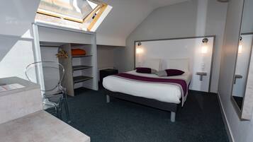A bedroom with a skylight, a bed with a headboard, a bedside table, and a chair.
