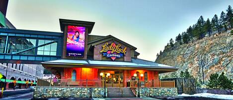 A casino building with a prominent sign, a stone facade, and a staircase leading to the entrance.