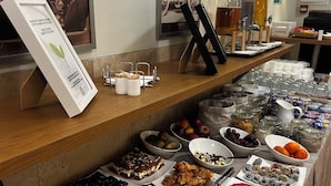 Un buffet proposant une variété de plats, notamment des pâtisseries, des fruits et des desserts.