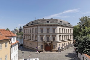 Um edifício histórico com um pátio central, janelas amplas e uma entrada imponente.