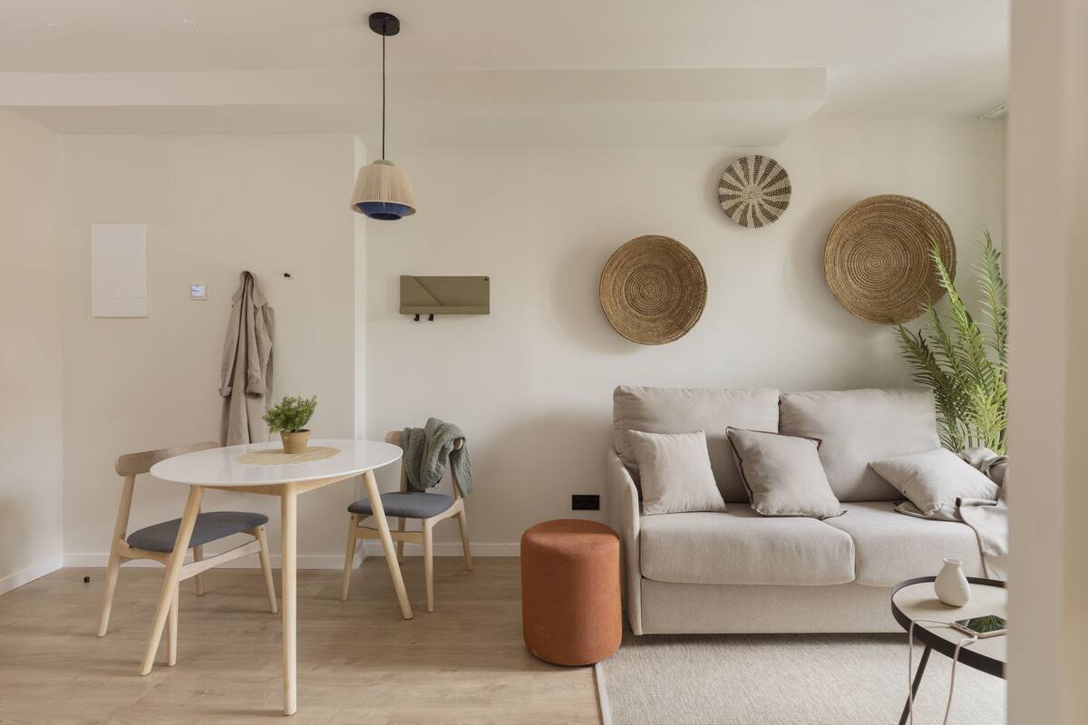 Un salon moderne avec une table ronde, deux chaises, un canapé et une table basse.