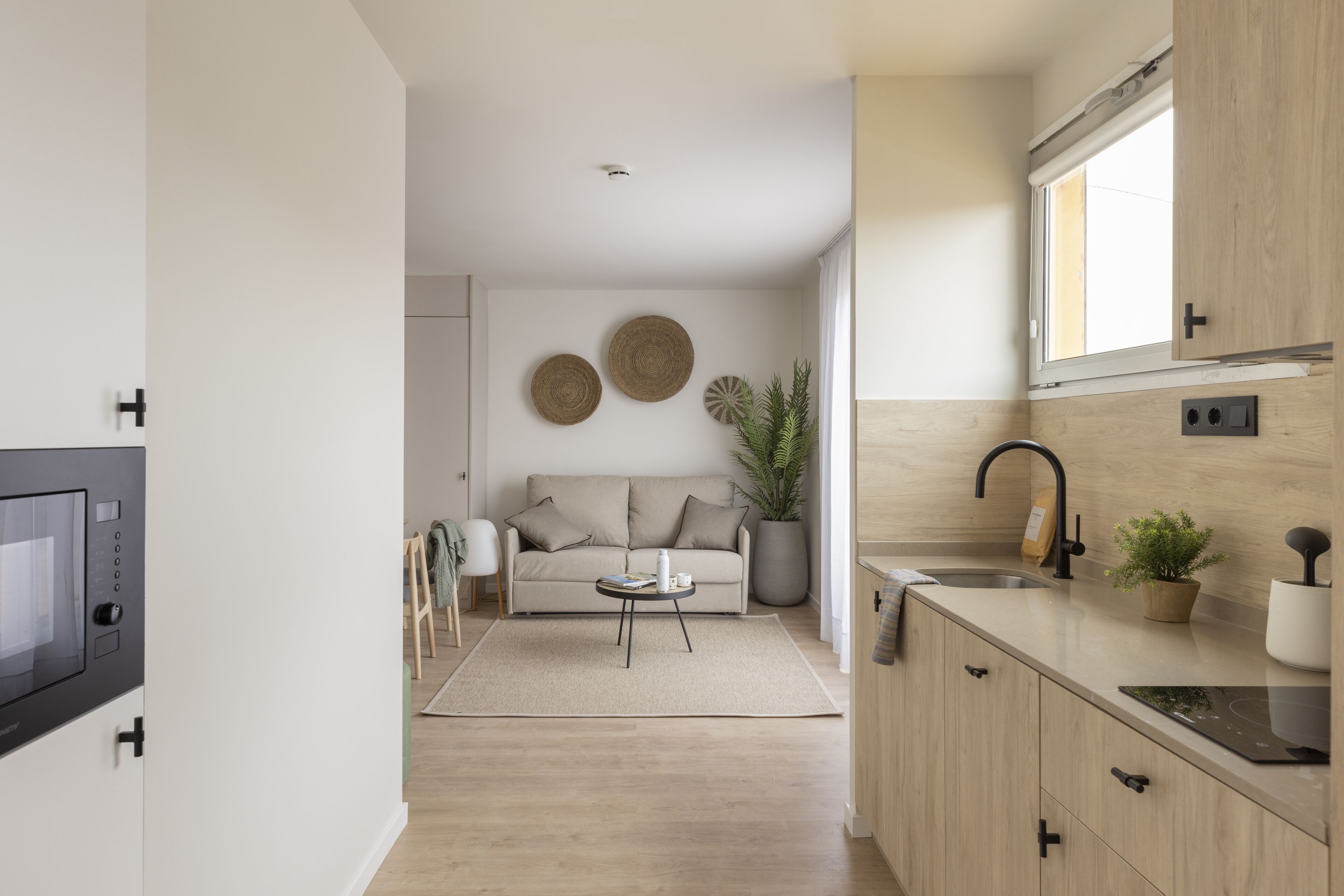 Una cocina moderna con microondas incorporado, un lavabo y una ventana.