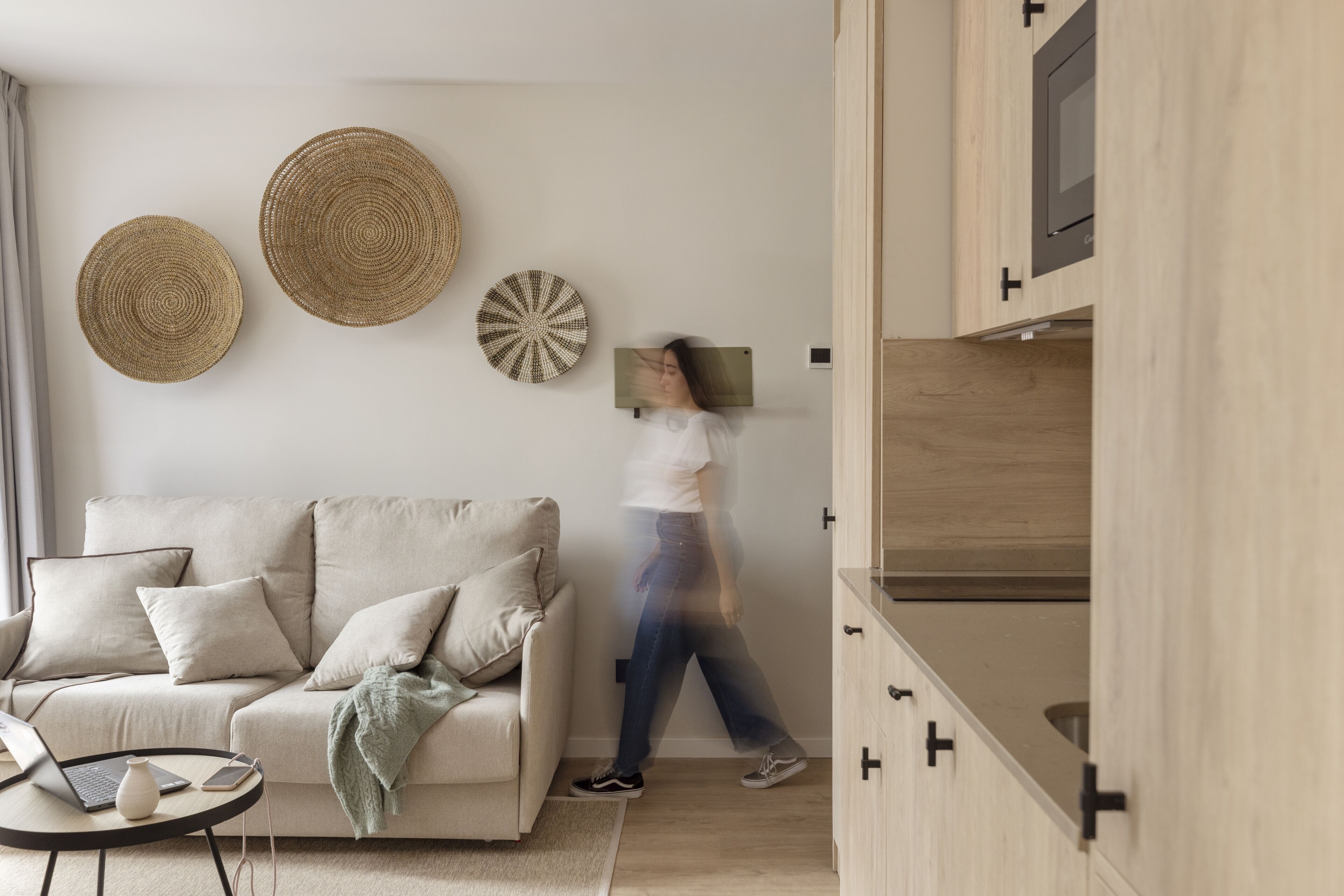 Un salon moderne avec un canapé, une table basse et des éléments décoratifs fixés au mur.