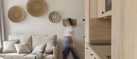 A modern living room with a sofa, a coffee table, and decorative wall hangings.