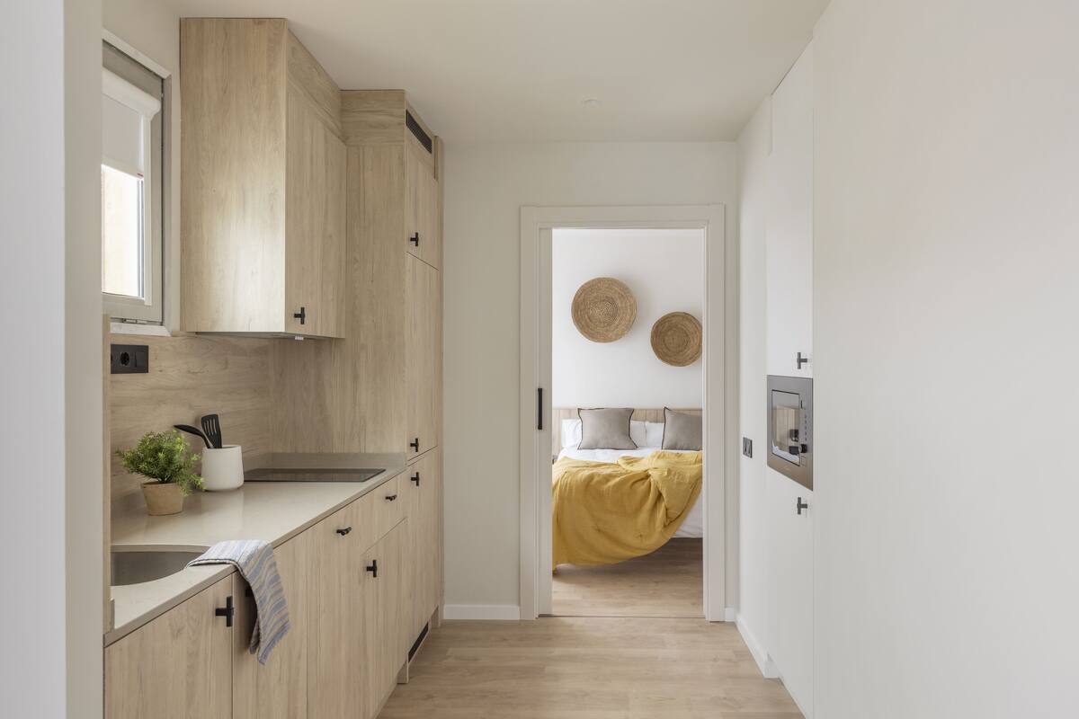 Une cuisine moderne avec des meubles en bois, un évier et une plante en pot.